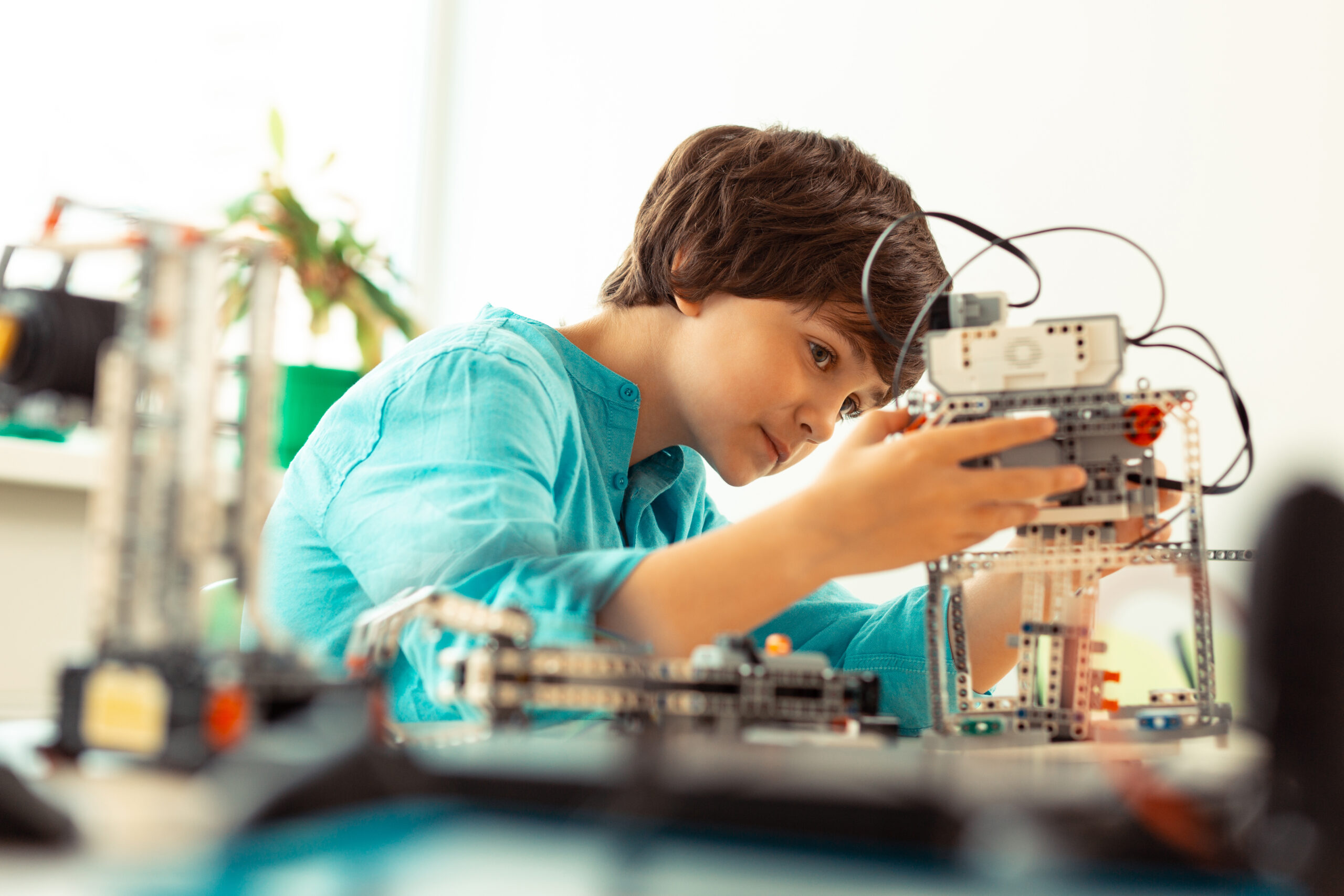 Enthusiastic pupil fixing the robot at science lesson